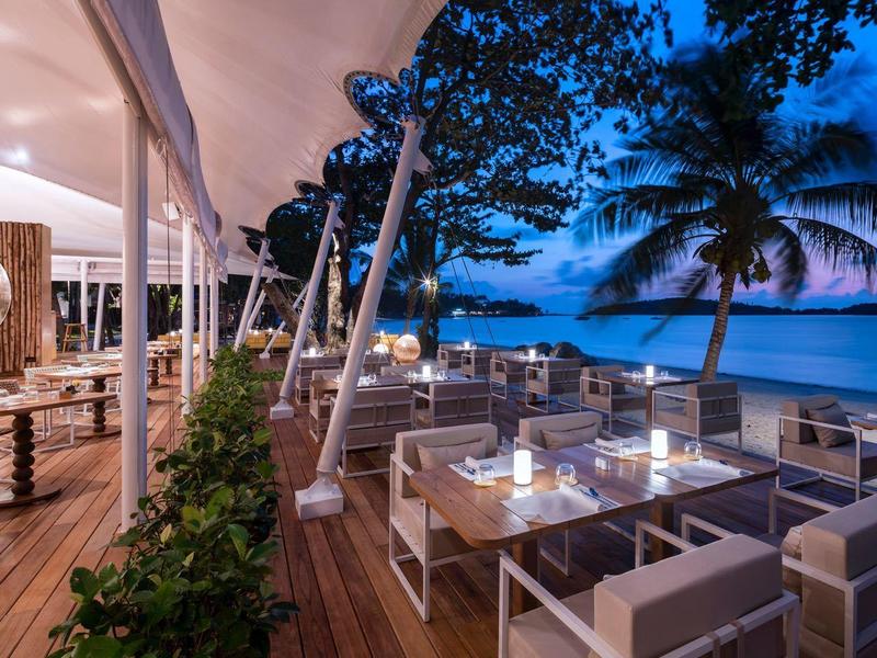 Ristorante sulla spiaggia con posti a sedere moderni e vista mare al crepuscolo
