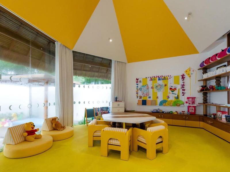 Sala giochi colorata e moderna per bambini con moquette gialla e mobili a misura di bambino.