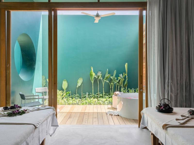 Stanza spa moderna con lettini da massaggio e vista su un giardino verde