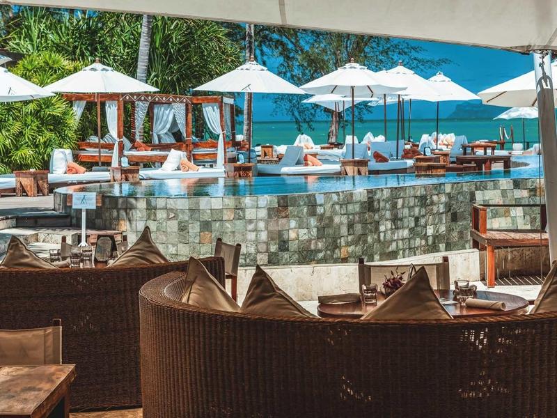 Buitenzwembad met ligstoelen en parasols in een hotelsfeer met vakantiesfeer.