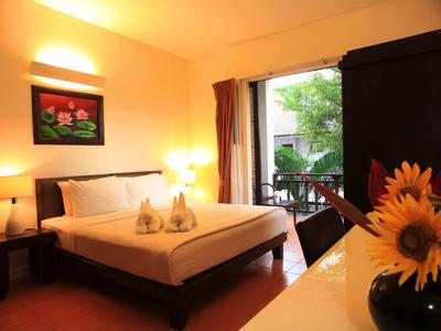 Gemütliches Hotelzimmer mit großem Bett, Balkon und warmem Licht.