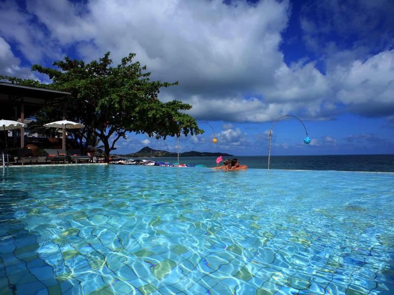 Przejrzysta woda basenu infinity z widokiem na ocean i pochmurne niebo w tropikalnym ośrodku.