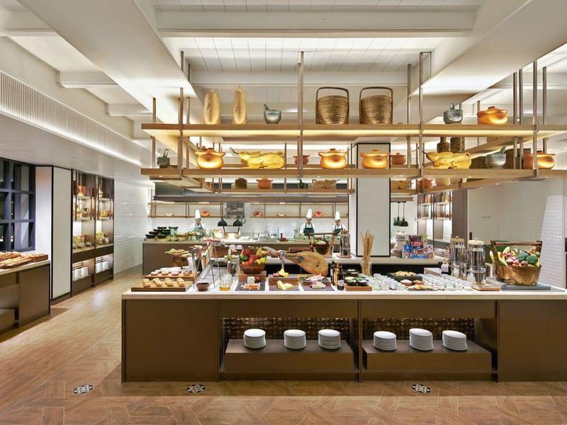 Moderní bufet v hotelové restauraci s různými jídly a teplým osvětlením.