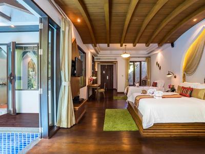 Chambre d'hôtel luxueuse avec lit double, plafond en bois et accès à une piscine.