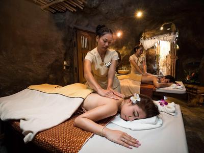 Femme recevant un massage relaxant dans un spa chaleureux avec une lumière douce.