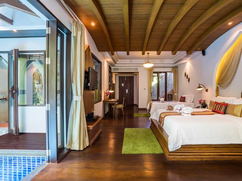 Chambre d'hôtel luxueuse avec lit double, plafond en bois et accès à une piscine.