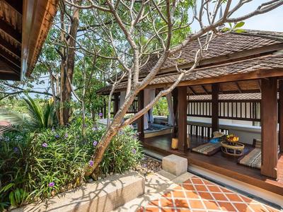 Příjemný zastřešený salón s dřevěnou konstrukcí a tropickou zelení.