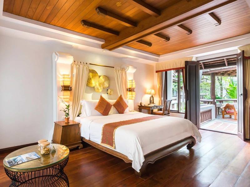 Pohodlný hotelový pokoj s dřevěnou podlahou, velkou postelí a přístupem na terasu.