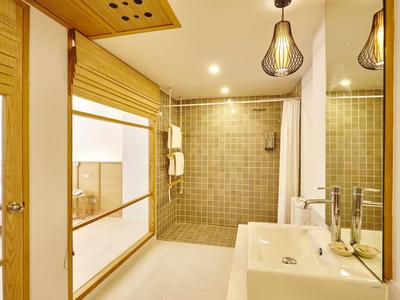 Jasna łazienka z nowoczesnym prysznicem, umywalką i dekoracyjnymi drewnianymi akcentami.