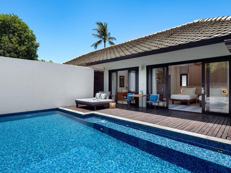 Bungalow moderne avec terrasse, piscine, chaises longues, ciel bleu et palmier