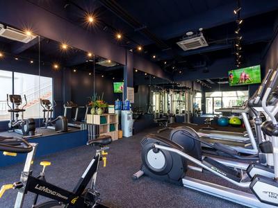 Moderner Fitnessraum mit Cardio- und Kraftgeräten in Hotelumgebung