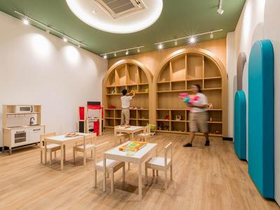 Moderní herní prostor s dřevěným nábytkem a barevnými doplňky v hotelu.