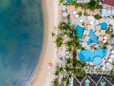 Letecký pohled na resort s bazénem, písečnou pláží a oceánem