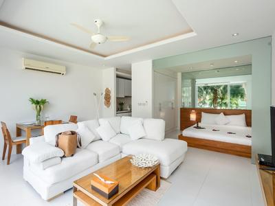 Sala moderna con sofá blanco, mesa de comedor y ventana grande.