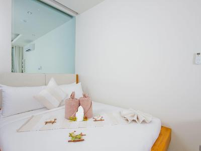 Habitación de hotel luminosa con una cama limpia y arte de toallas sobre la cama.