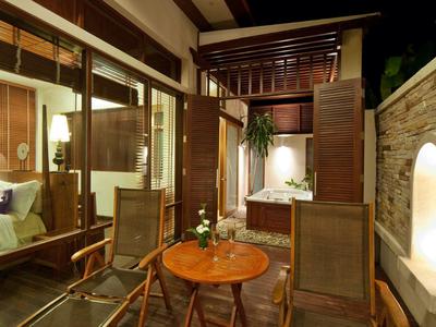 Espace extérieur confortable avec mobilier en bois et bain à remous ouvert la nuit