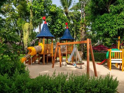 Bunter Kinderspielplatz mit Rutschen und Schaukeln in einem tropischen Garten