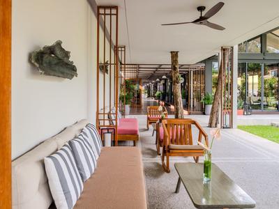 Moderner Hotel-Außenbereich mit Sitzgelegenheiten und Blick auf eine grüne Gartenanlage.