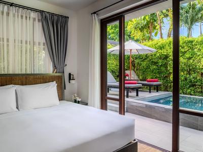 Schlafzimmer mit großem Bett und Blick auf einen Pool und eine Terrasse im Freien.