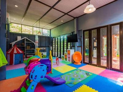 Bunter Indoor-Kinderspielbereich mit Spielzeug und weichen Matten in einem Hotel.