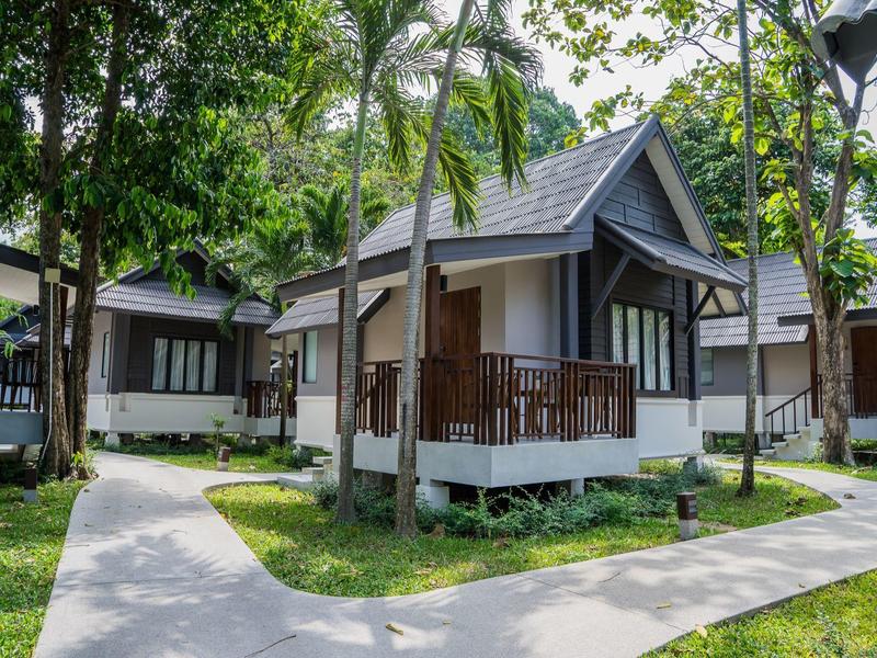 Kleine Gästehäuser mit Veranden in tropischer Umgebung mit Palmen