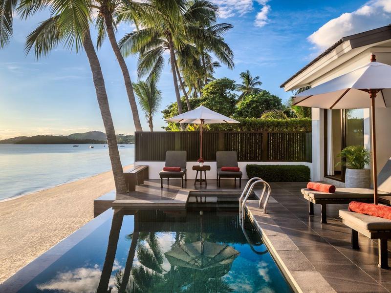 Luxuriöse Unterkunft mit privatem Pool direkt am Strand unter Palmen bei Sonnenuntergang.