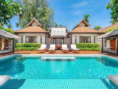 Villa di lusso con piscina privata, lettini e vegetazione tropicale sotto un cielo terso