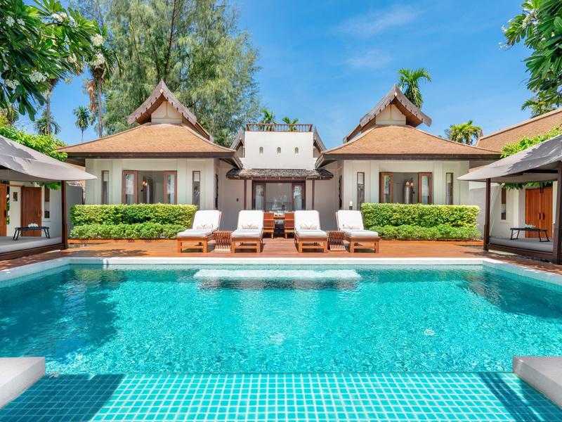 Bungalows de lujo con piscina privada, rodeados de vegetación verde y cielo azul.