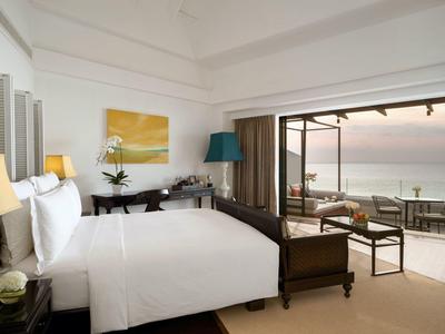 Habitación de hotel moderna con cama grande y terraza con vistas al mar.