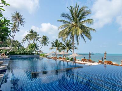 Infinity-Pool mit Blick auf den Ozean und Palmen am tropischen Hotelstrand.