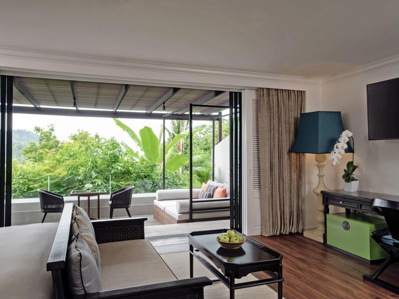 Sala moderna con vista a una terraza verde y grandes ventanas.