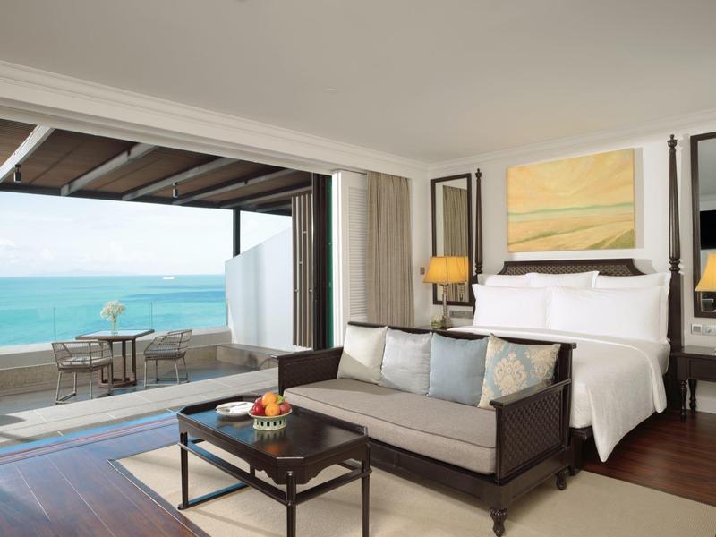 Habitación de hotel elegante con vista al mar y balcón con zona de estar