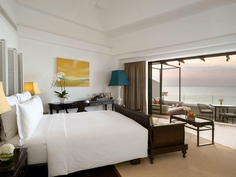 Habitación de hotel moderna con cama grande y terraza con vistas al mar.