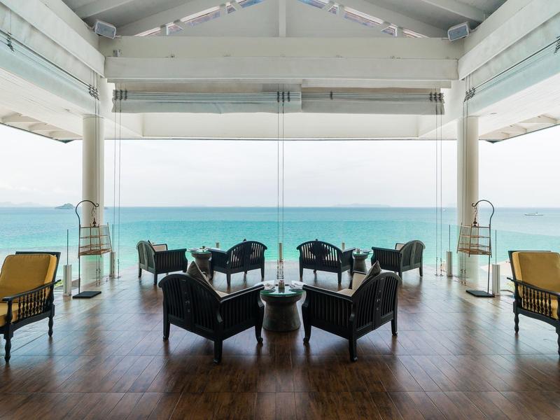 Área de salón abierta con sillones con vista al mar.