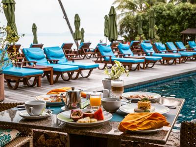 Gemütlicher Spa-Raum mit Massagebank, Whirlpool und Kerzenbeleuchtung.