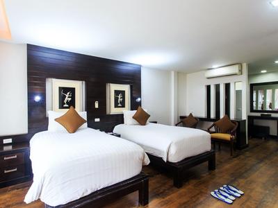 Nowoczesny pokój hotelowy z dwoma pojedynczymi łóżkami, ciemnym drewnem i minimalistycznym designem.