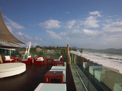 Terrace with modern seating overlooking the beach and sea under a partly cloudy sky