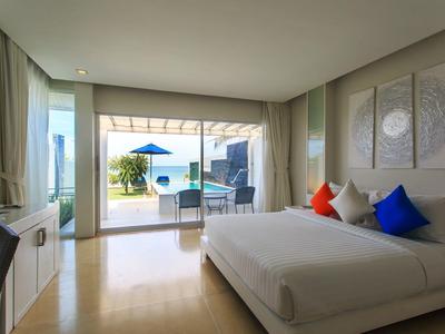 Habitación de hotel moderna con cama grande, balcón y vista a la piscina.