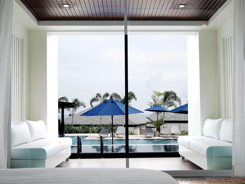 Habitación de hotel con balcón abierto, vista a la piscina y palmeras a la luz del día