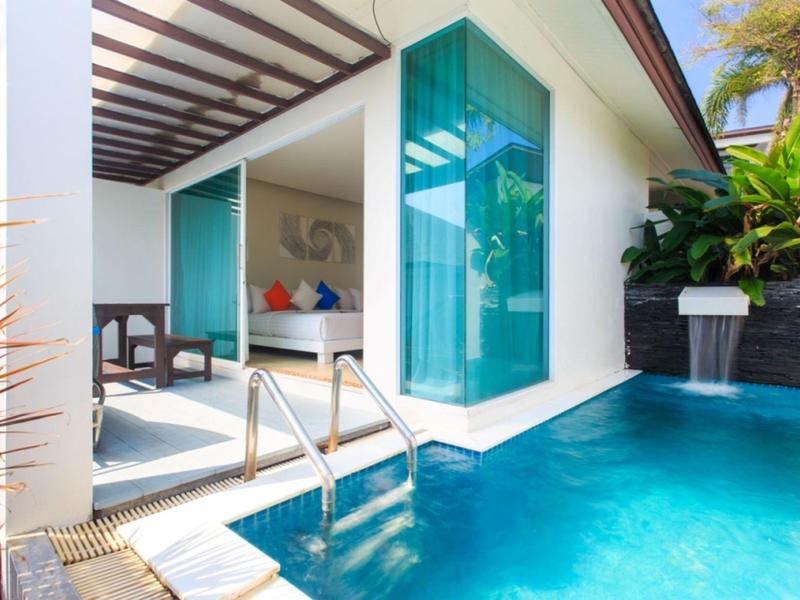 Zona de piscina con escaleras frente a una terraza luminosa y fachada de vidrio con vista al interior.