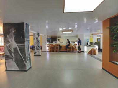 Ruime hotel lobby met zitplaatsen en kunst aan de muren.