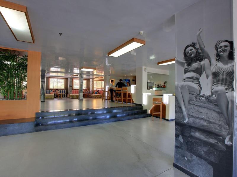 Ruime binnenruimte met traptreden, zithoek en zwart-wit foto op pilaar