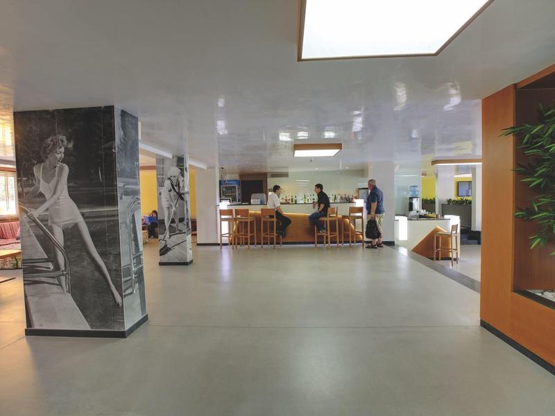 Ruime hotel lobby met zitplaatsen en kunst aan de muren.