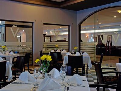 Elegantes Restaurant mit weiß gedeckten Tischen und gelben Blumen in modernen Interieur