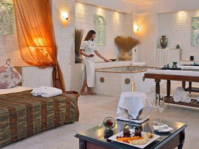 Ein eleganter Wellnessraum mit Massagebank, Sofabereich und gedämpftem Licht.