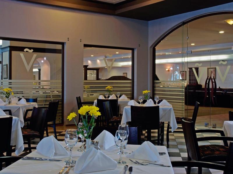 Elegantes Restaurant mit weiß gedeckten Tischen und gelben Blumen in modernen Interieur