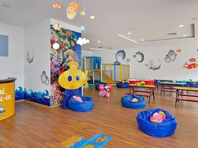 Kinder-Spielzimmer mit bunten Möbeln und Spielzeugen, Holzboden und Wanddekorationen.