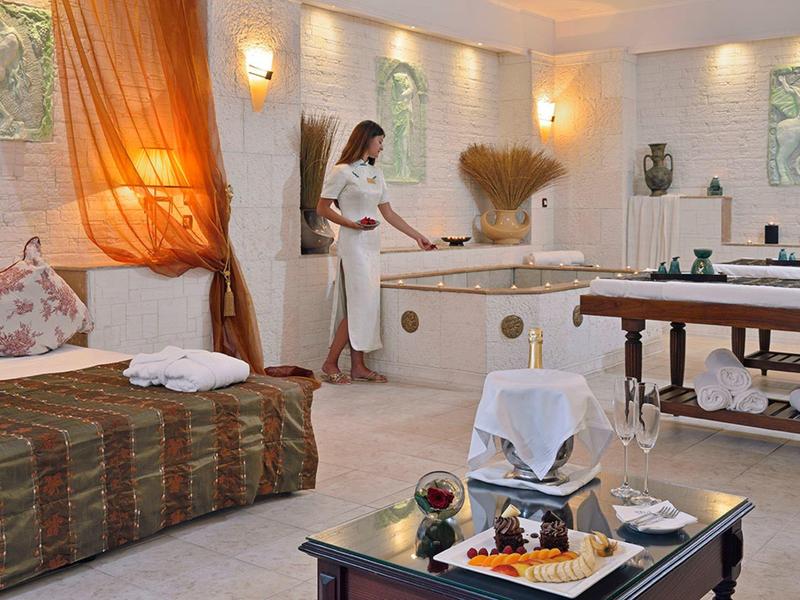 Ein eleganter Wellnessraum mit Massagebank, Sofabereich und gedämpftem Licht.