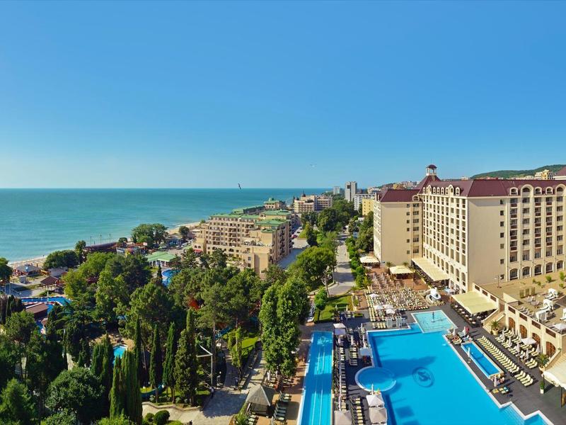 Hotelanlage mit großem Pool an der Küste und Blick auf das Meer bei klarem Himmel
