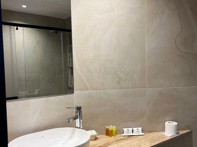 Moderner Badezimmerwaschtisch mit ovalem Waschbecken und Holzablage.